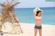 A woman in a bikini standing on a beach.