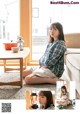 A woman sitting on the floor holding a lantern.