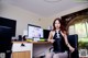 A woman sitting at a desk in front of a computer.