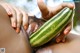 A woman holding a watermelon in her hand.