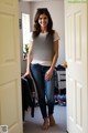 A woman standing in front of a door in a room.